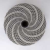 A black-on-white seed pot decorated with a spiral mesa geometric design
 by Robert Kasero Sr of Laguna