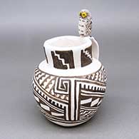 Polychrome jar with a handle, a black-on-white painted kiva step and geometric design, and a miniature owl figure perched on the rim
 by Kimo DeCora of Isleta