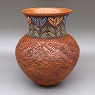 Polychrome jar with a flared opening, an organic coiled body, and a sgraffito, coiled, and painted flower design around neck
 by Richard Zane Smith of Wyandot