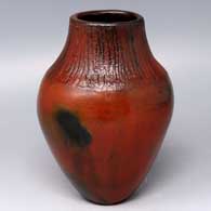 Brown jar with fire clouds and a corn husk surface above the shoulder
 by Alice Cling of Dineh
