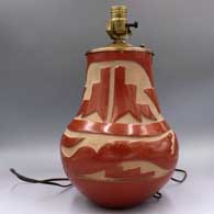 Red jar carved with an avanyu and geometric design, drilled and mounted with lamp hardware, click or tap to see a larger version