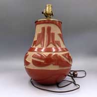 Red jar carved with an avanyu and geometric design, drilled and mounted with lamp hardware, click or tap to see a larger version