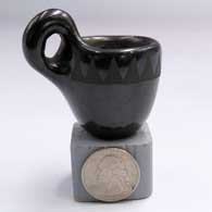 Miniature black-on-black cup with a handle and a geometric design around the rimG23
 by Unknown of Santa Clara