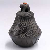 Small black jar with a sgraffito avanyu and geometric design with a bear-figure lid with pieces of colored stone on its backJ40
 by Joseph Lonewolf of Santa Clara