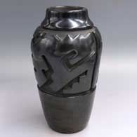 Tall black jar carved with a stylized avanyu design, First Prize ribbon NM State Fair 1969
 by Virginia Ebelacker of Santa Clara