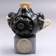Small black canteen with handles and carved with an avanyu design on the front and rearH07
 by Shirley Tafoya of Santa Clara