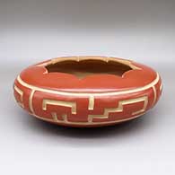 Red bowl with a fluted geometric cut opening and a carved geometric design
 by LuAnn Tafoya of Santa Clara