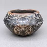 Small black bowl with a sienna rim and a sgraffito avanyu, bear paw, medallion, feather ring, spiral, and geometric design
 by Kevin Naranjo of Santa Clara