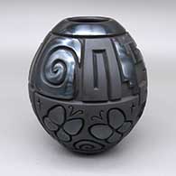 Black jar with a carved butterfly, bear, spiral, kiva step, and geometric design and polished and matte details
 by Harrison Begay Jr of Santa Clara