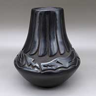 Black jar with a carved avanyu and feather ring geometric design
 by Chris Martinez of Santa Clara