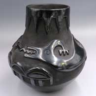 Black jar carved with an avanyu design above the shoulder and a geometric design around the neck
 by Juanita Pena of San Ildefonso
