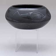 A black-on-micaceous black bowl decorated with an avanyu and geometric design
 by Johnny Cruz of San Ildefonso