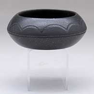 A black-on-micaceous black bowl decorated with a cloud pattern above the shoulder
 by Johnny Cruz of San Ildefonso