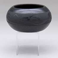 A black-on-micaceous-black bowl decorated with an avanyu and geometric design
 by Johnny Cruz of San Ildefonso