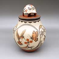 Polychrome lidded jar with a hummingbird, butterfly, flower, fine line, and geometric design and a matching lid with an applique bear and a painted roadrunner design
 by Marcellus Medina of Zia