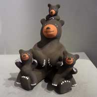 A bear storyteller figure with three cubs
