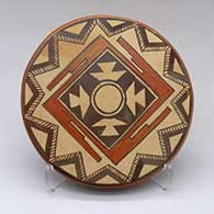 A polychrome round tile decorated with a geometric design