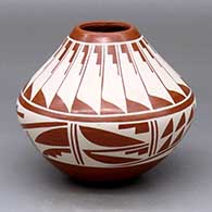 A white-on-red jar decorated with a band-of-feathers and geometric design around the body and neck