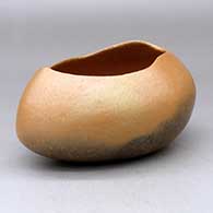 A golden micaceous pot with an organic opening and fire clouds
