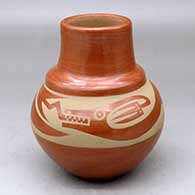 A buff-on-red double-shouldered jar decorated with an avanyu design around the body