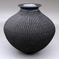 A black jar with a polished, rolled lip and a corrugated body
