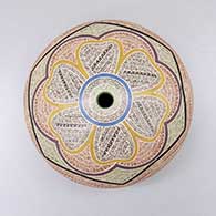 A polychrome seed pot decorated with a sgraffito and painted floral and fine line geometric design