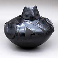 A black-on-black owl effigy jar decorated with wing appliques and geometric designs