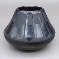 A black-on-black jar decorated above the shoulder with a ring of feathers geometric design