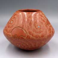 A red jar with a sgraffito bear and geometric design plus inlaid stones