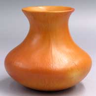 A plain, polished orange water jar