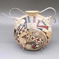 A polychrome marbleized clay canteen with a flared opening, a painted tiny squares and geometric design, and a leather strap detail