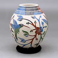 A polychrome jar decorated with a three-panel hummingbird, branch, leaf, flower and geometric design