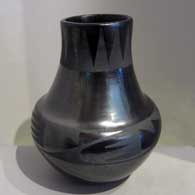 Geometric design around the shoulder and rim of a black on black gunmetal jar