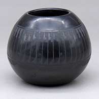 A black-on-black jar decorated with a ring of feathers design around the shoulder