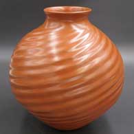 A red melon jar with a spiral ribs design