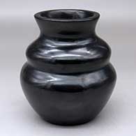 A plain, polished black double-shouldered jar with a flared rim