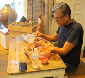 Hubert Candelario smoothing the inside of a piece he is just forming