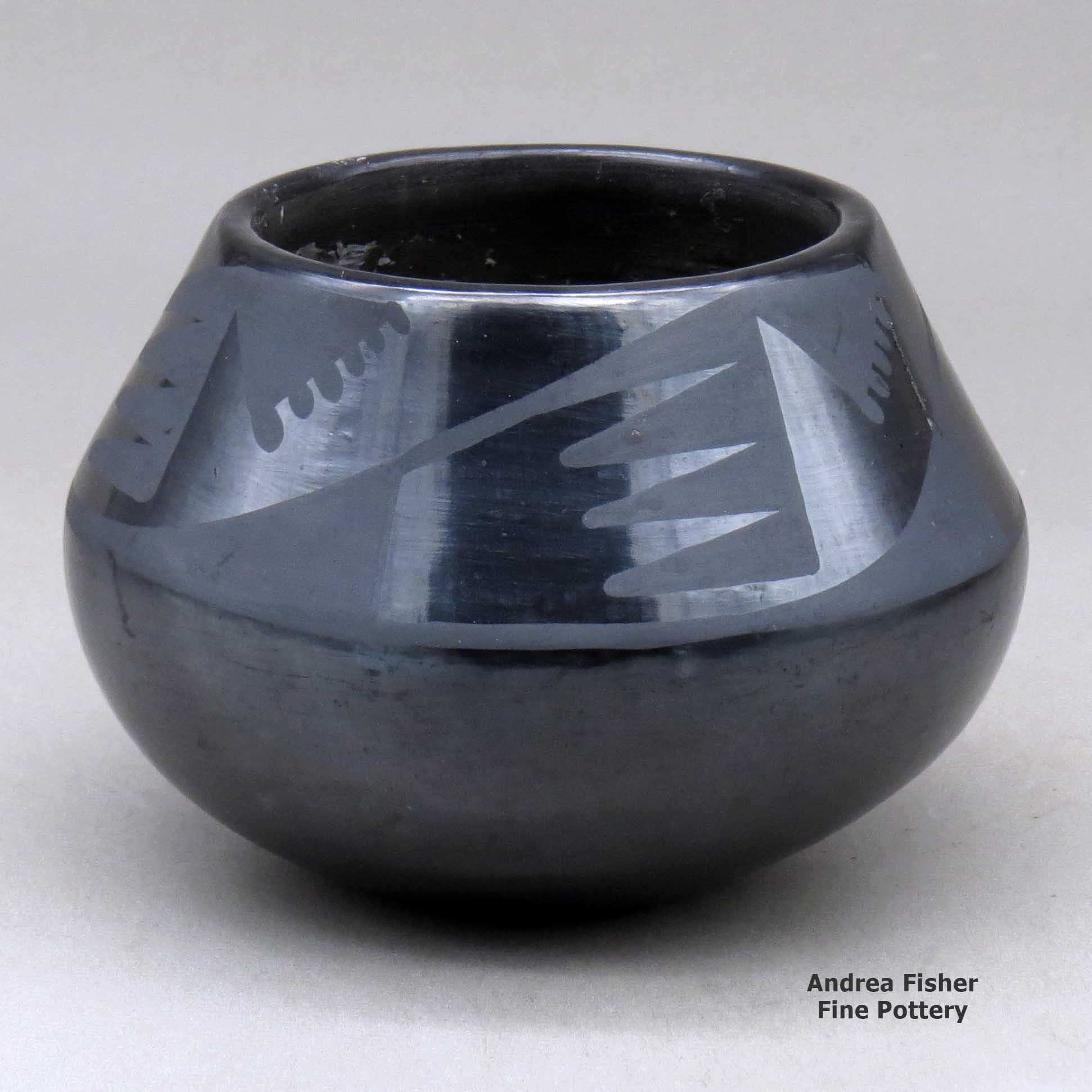 Click or tap to see a larger view A black on black jar decorated with a four panel bat wing and geometric design above the shoulder made by Maria Martinez of San Ildefonso