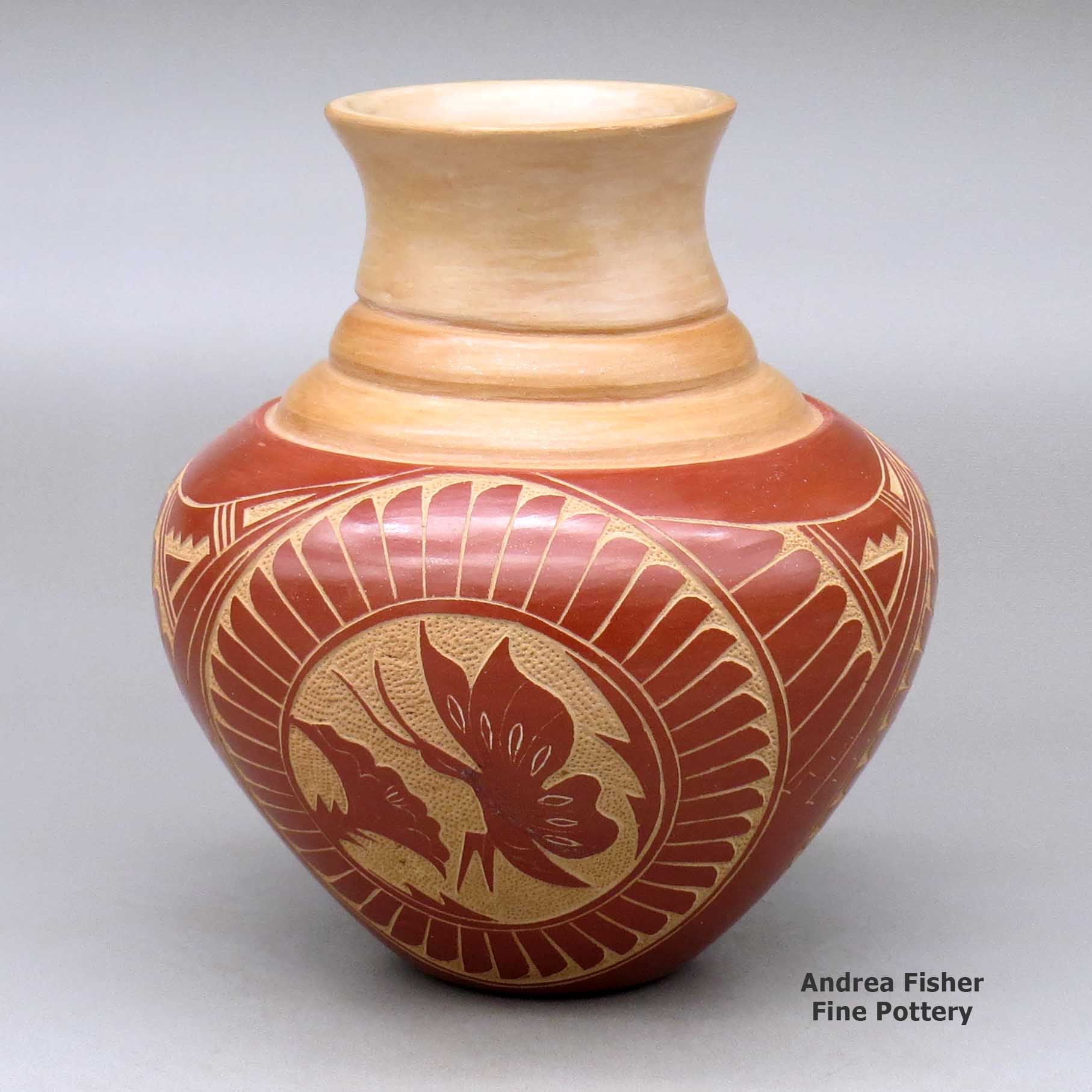 Click or tap to see a larger view A red on tan triple shouldered jar with a flared rim decorated with a three panel sgraffito butterfly, flower, feather and geometric design made by Vangie Tafoya of Jemez