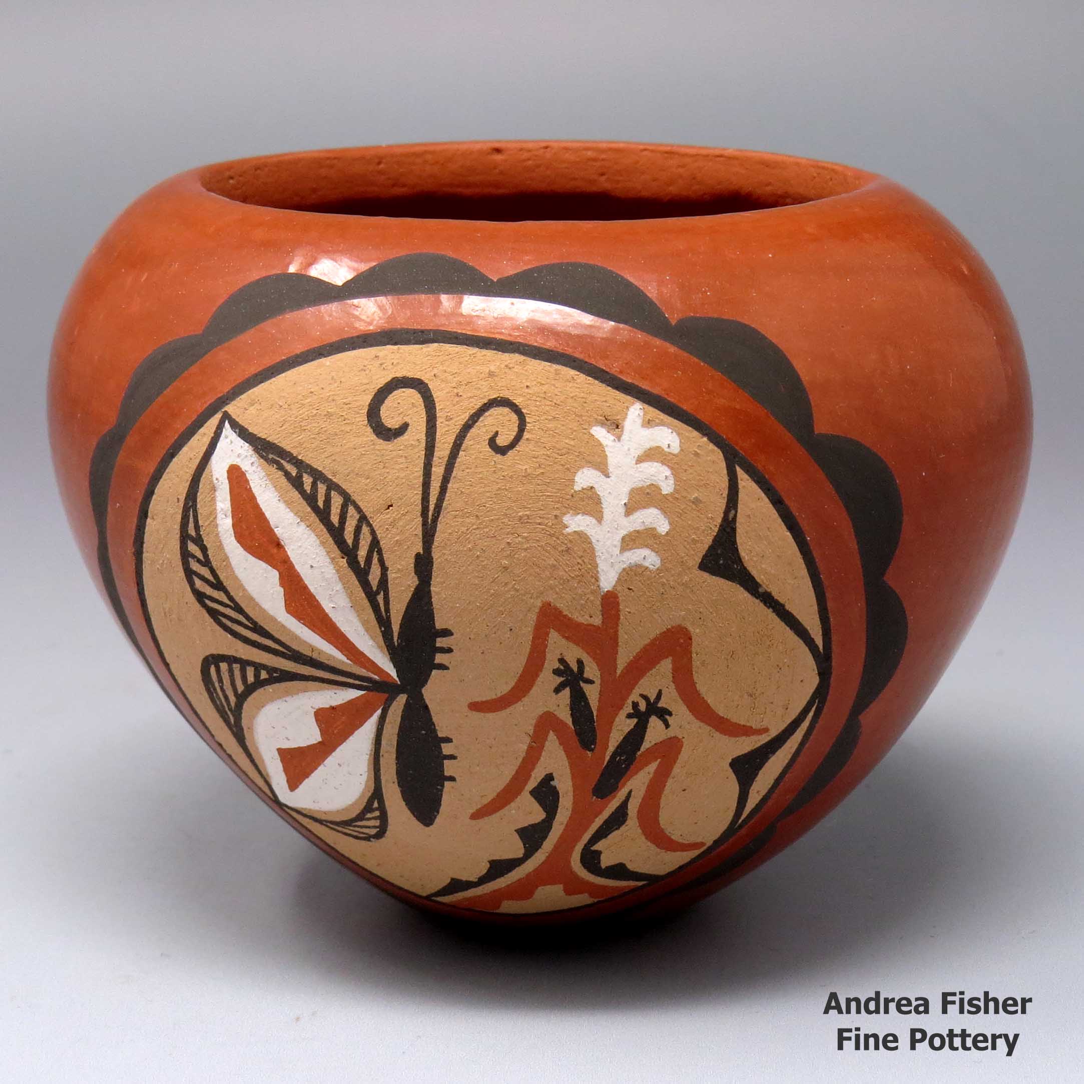 Small polychrome jar with a painted butterfly, corn plant and geometric design in a medallion made by Phyllis M Tosa of Jemez
