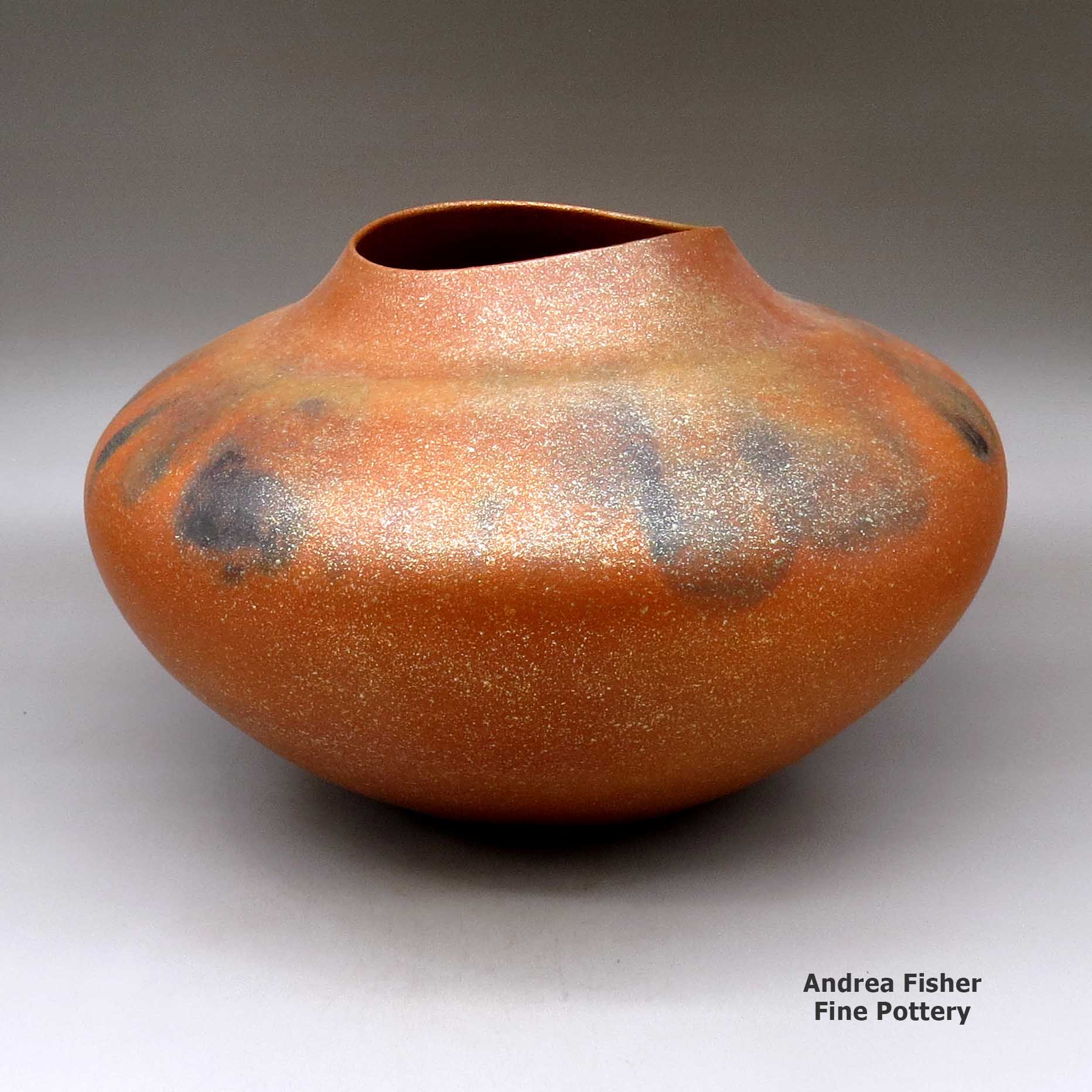 Click or tap to see a larger view A large orange micaceous jar with an organic opening and fire clouds made by Lonnie Vigil of Nambe