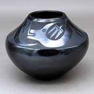 A black on black jar decorated with an avanyu and geometric design above the shoulder
 by Maria Martinez of San Ildefonso
