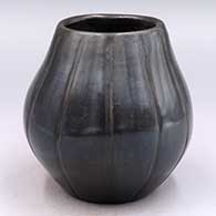 Black jar lightly carved with a melon design with 12 ribs
 by Mida Tafoya of Santa Clara