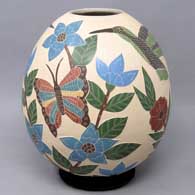 A polychrome jar decorated with a sgraffito and painted bird, butterfly, branch and flower design
 by Blanca Arras of Mata Ortiz and Casas Grandes