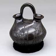 A small black on black wedding vase decorated with a geometric design
 by Baudel Lopez of Mata Ortiz and Casas Grandes