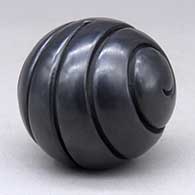 A black seed pot carved with a double spiral geometric design
 by Linda Tafoya of Santa Clara