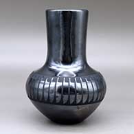 A black on black vase decorated around the shoulder with a band of feathers design, click or tap to see a larger version