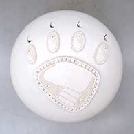 A white seed pot decorated with a sculpted bear paw applique
 by Wilfred Garcia of Acoma