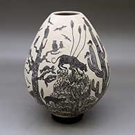 A black on white jar decorated with a sgraffito desert wildlife and nature design
 by Leonel Lopez Sr of Mata Ortiz and Casas Grandes