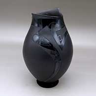 A black on black on black jar with a geometric cut opening and decorated with a a two panel geometric design
 by Lydia Quezada of Mata Ortiz and Casas Grandes